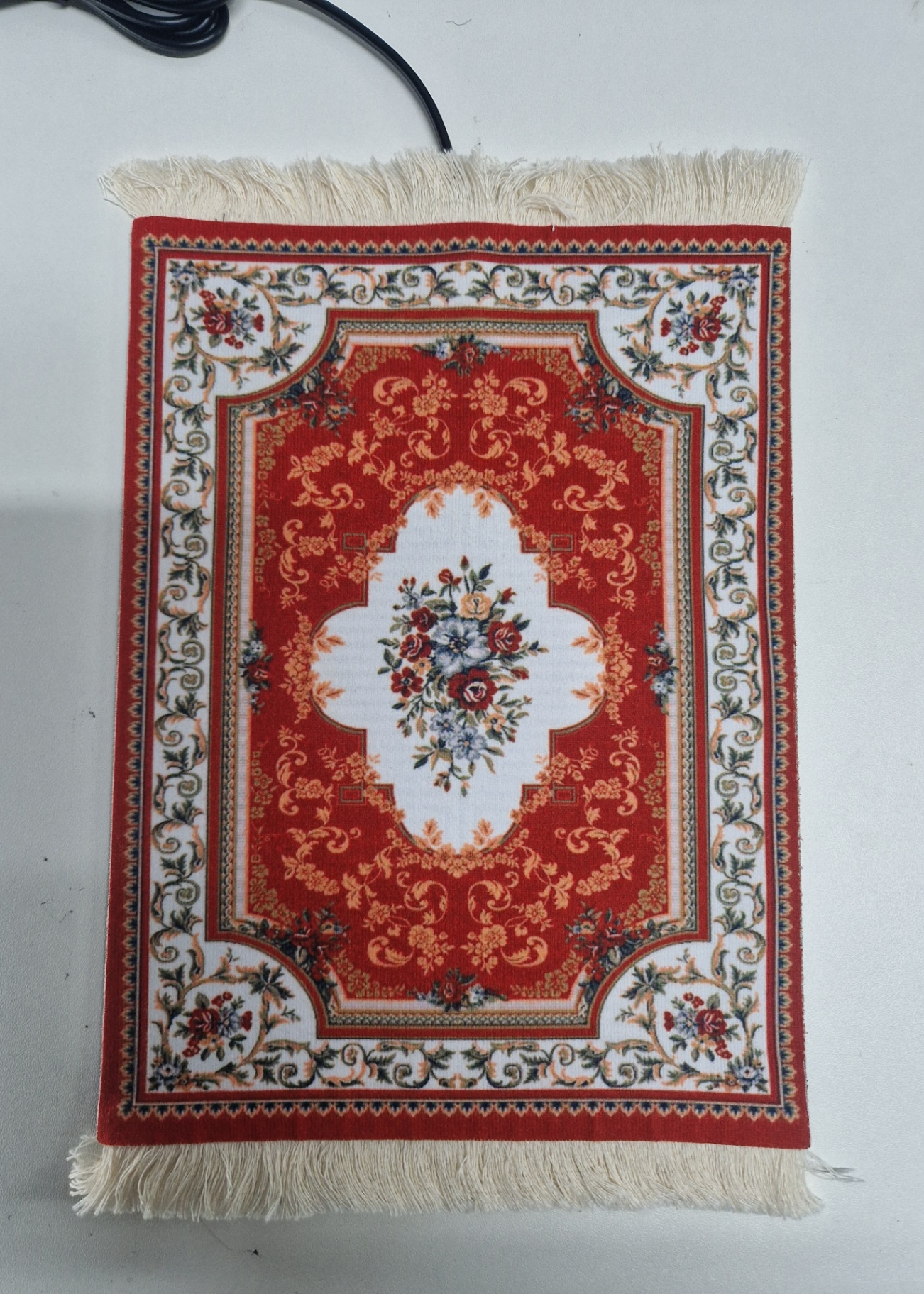 Bloemenrood van dichtbij — close-up van de verwarmde muismat met Perzisch design