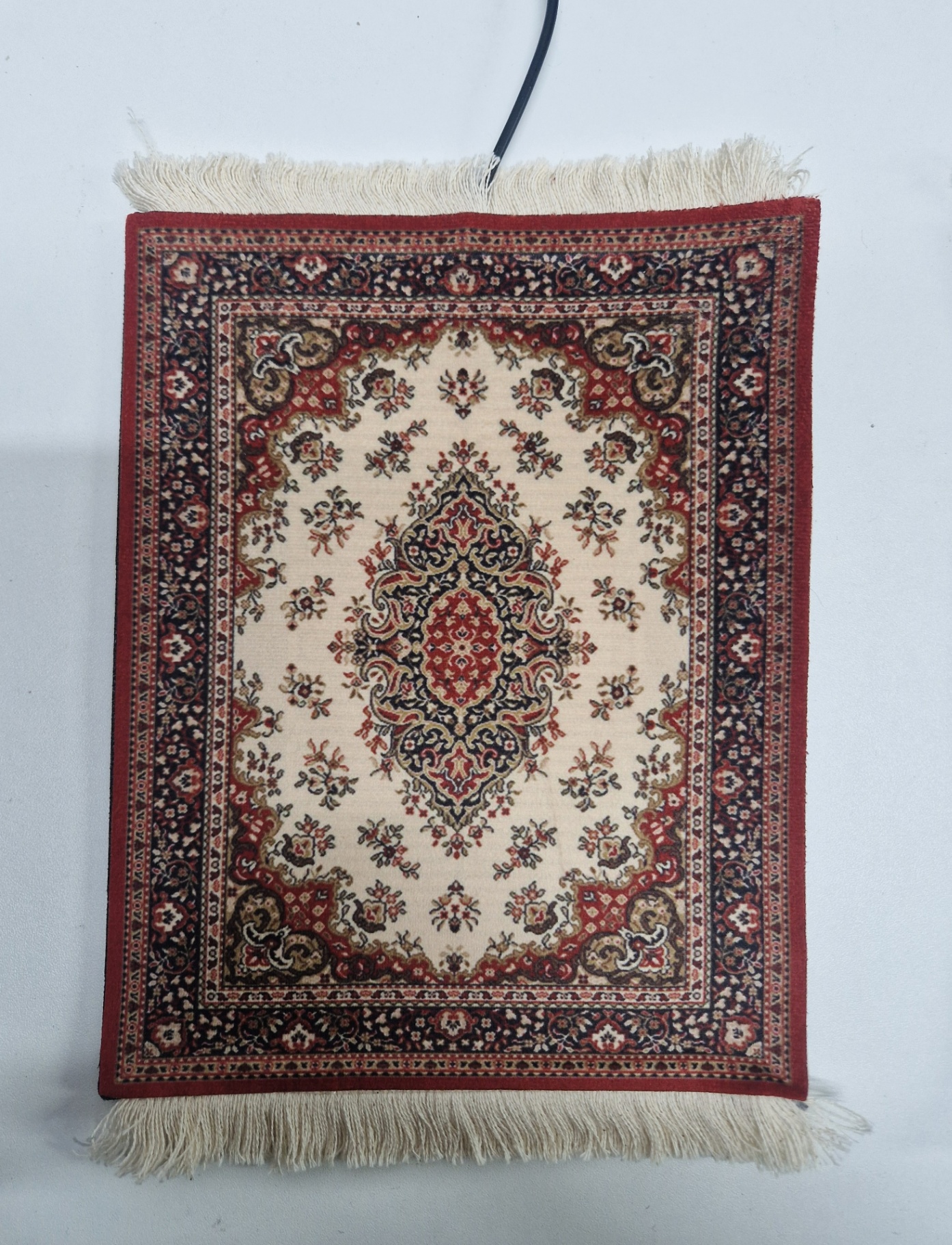 Medaillon van dichtbij — close-up van de verwarmde muismat met Perzisch design
